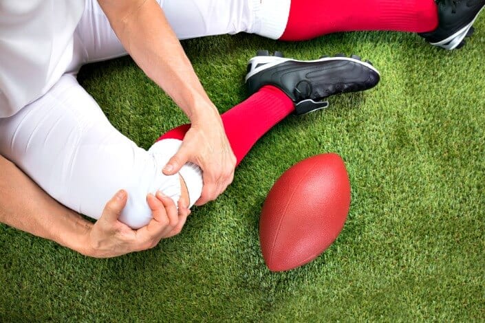 American Football player with knee injured knee