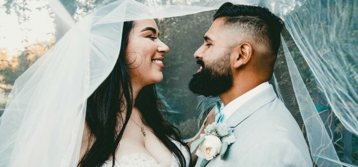 newlywed couple smiling at each other