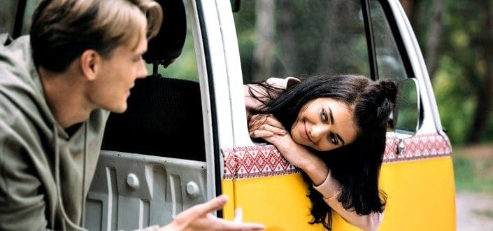 woman listening to a man talking inside a car