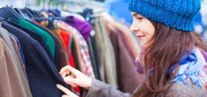 a woman choosing clothing from a rack of clothes