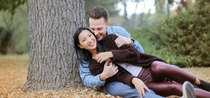 Couple enjoying sweet moments under the tree in a park