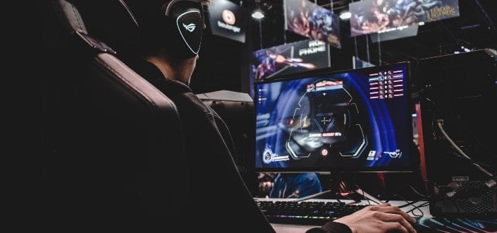 person sitting on gaming chair while playing computer