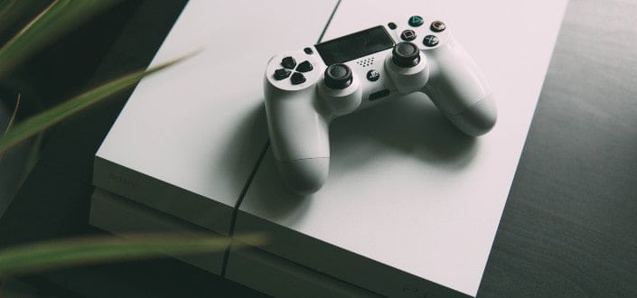 white Sony PS4 console place in the table