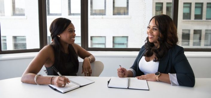 Two interviewees talking and taking notes