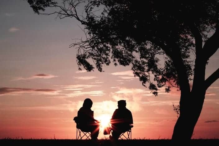 silhouette of couple sitting in sunset