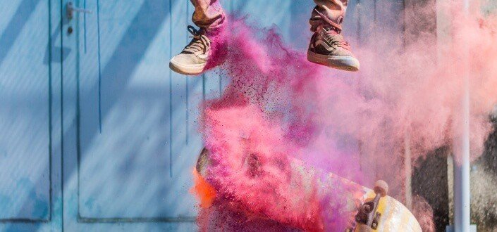 skater doing tricks with colored smoke bomb