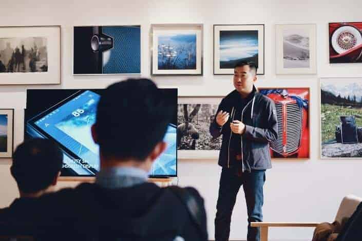 asian man speaking in front of audience