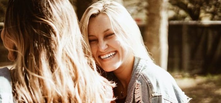 Beautiful girl smiling with cropped friend