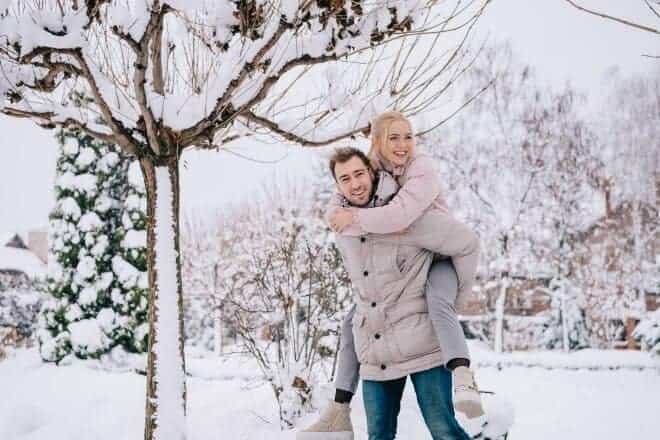 couple doing a piggyback pose - winter date ideas