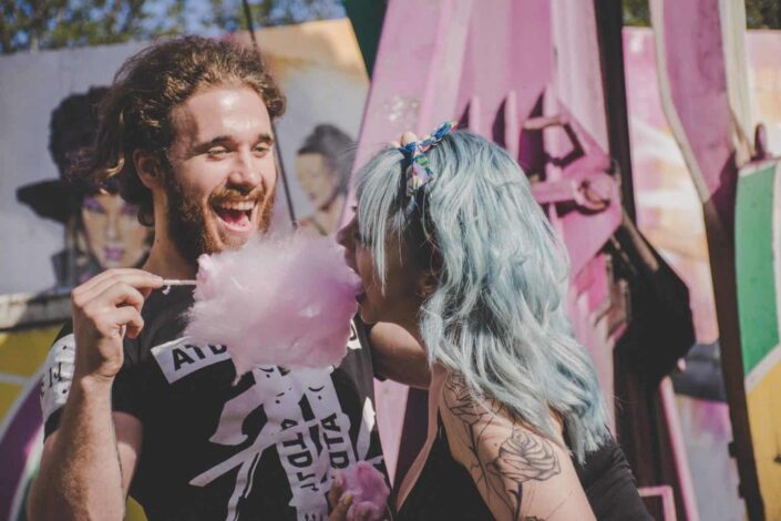 Couple having fun while eating a cotton candy.