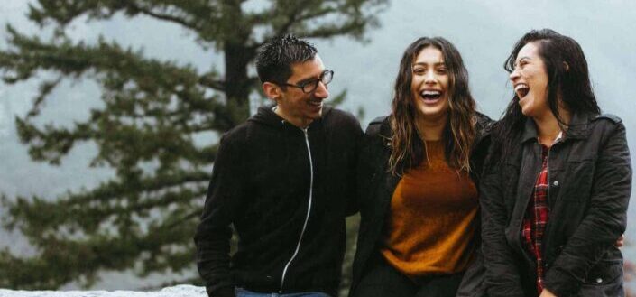 man standing beside two women in nature