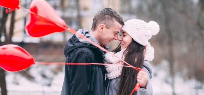 Woman Holding Balloons While Hugging a Man