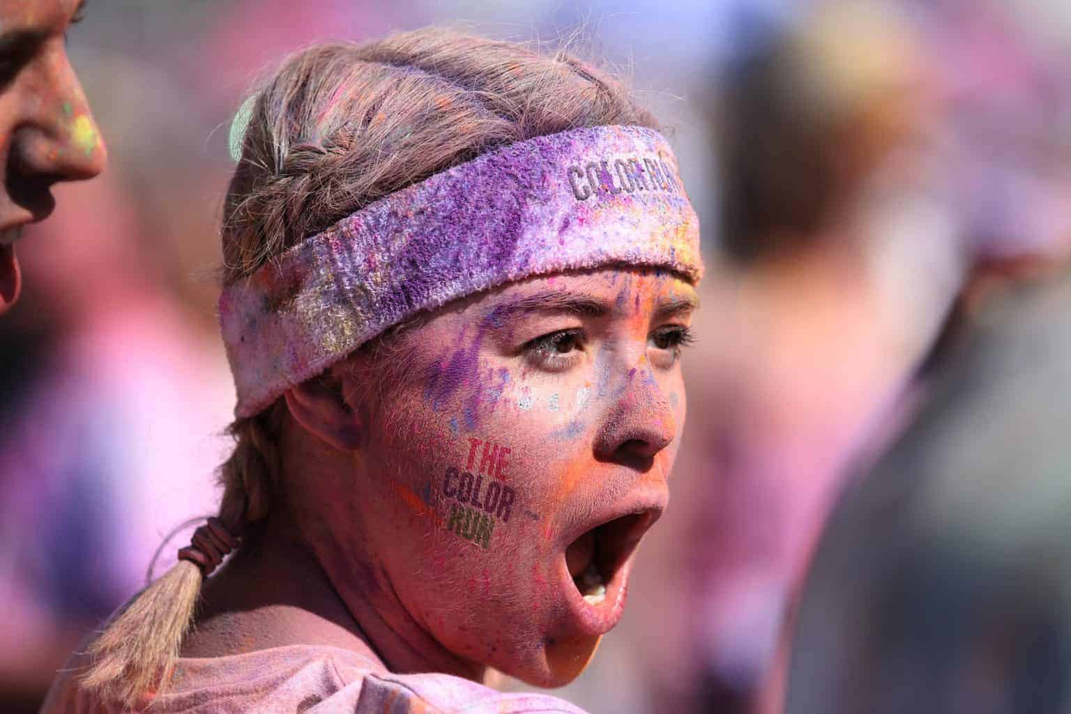 A young girl filled with face paint yelling out of excitemen