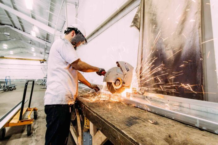 Man busy cutting a long steel with a hacksaw