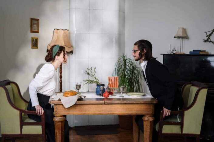 A man and a woman about to sit down for a meal 