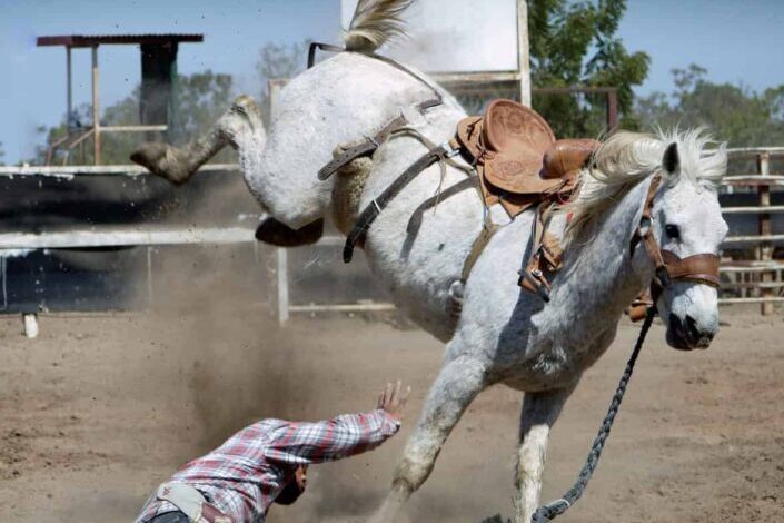 A horseback rider falling from his horse