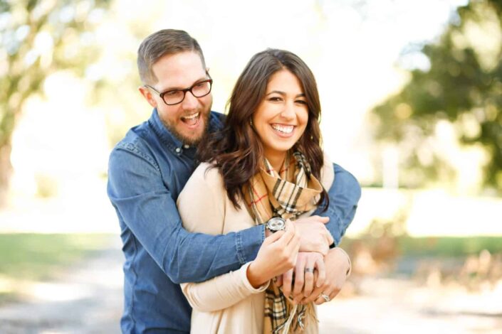 Man delightedly embraces his woman from behind