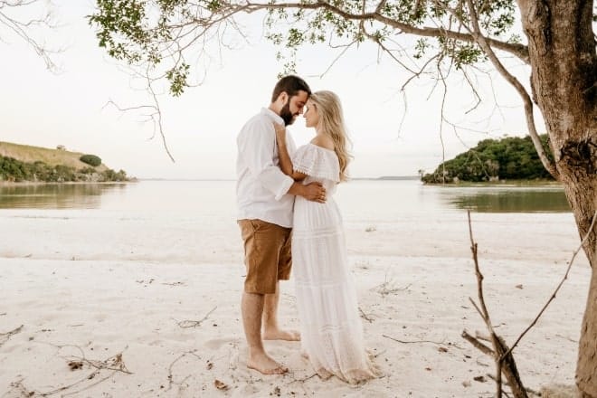 Couple staring at each other by the beach - romantic things to do for your girlfriend