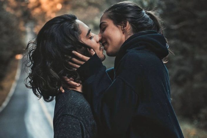 A couple in the middle of the road about to kiss