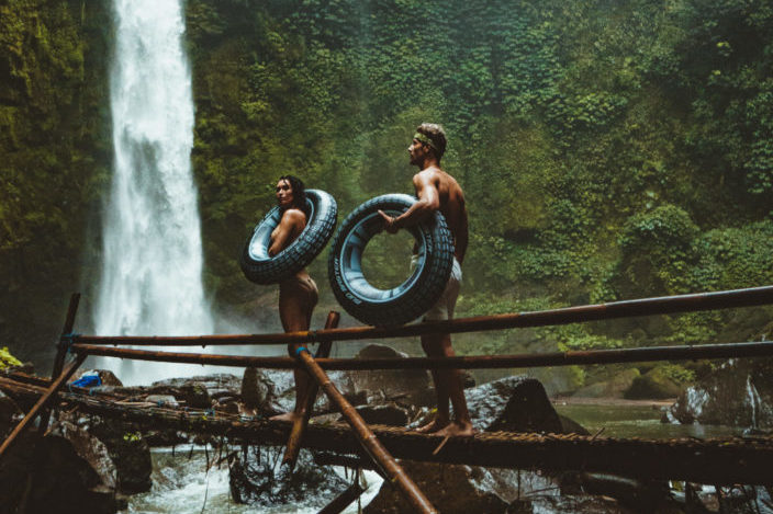 A couple with tires walking towards waterfalls