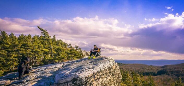 man sitting at the edge of mountain