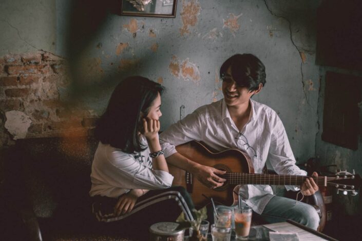 Man playing guitar while staring at the girl.