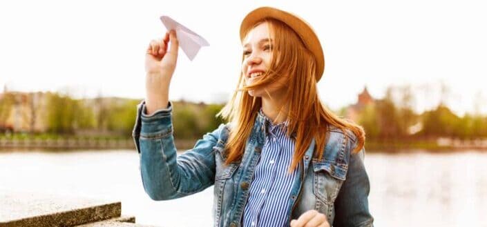 Young woman flies paper plane