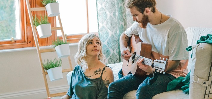 man playing a guitar for his girlfriend