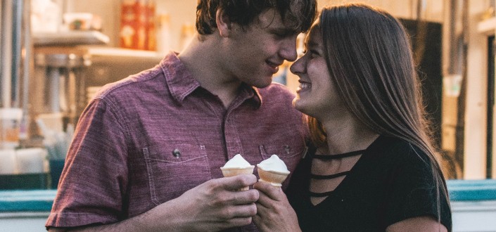 couple holding ice cream while giggling