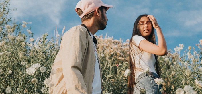 man looking at woman in a field of flowers