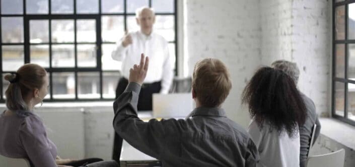 Man raising hand to ask a question.