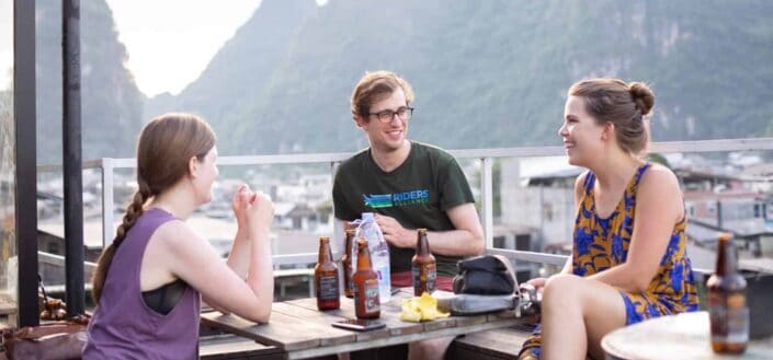 Three friends having a beer at a rooftop.