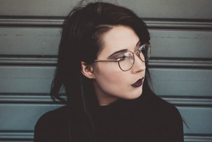 Girl wearing all black and black lipstick posing.