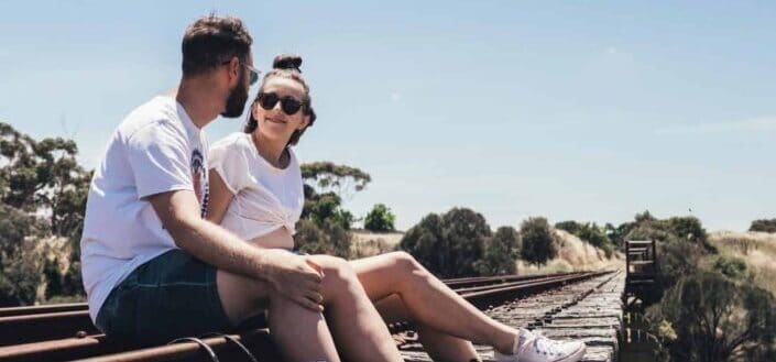 Couple Sitting On a Train Railway