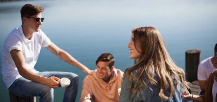 friends talking on a platform beneath lake