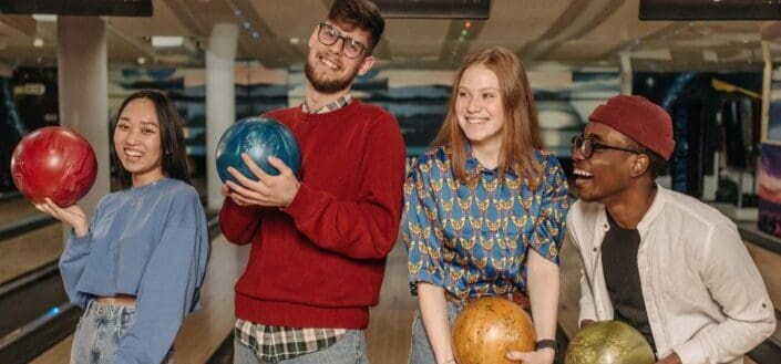 close-up-shot-of-a-group-of-friends-holding-bowling-balls-pexels
