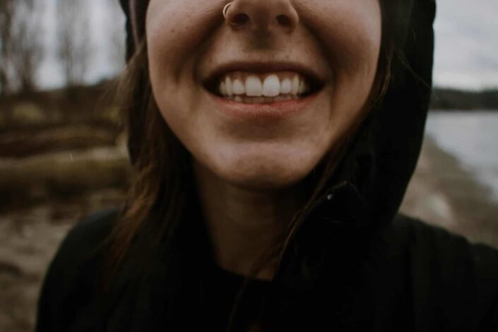 Woman in hoodie smiling at camera