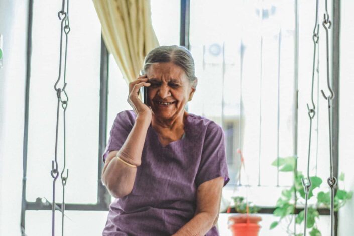 Old woman talking on the phone laughing