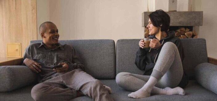 Happy young couple taking on sofa at home