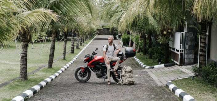 male biker sitting on motorcylce on pathway