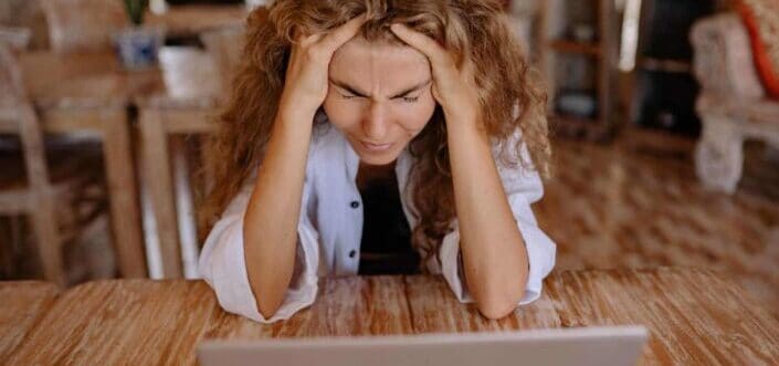 Frustrated woman facing her laptop