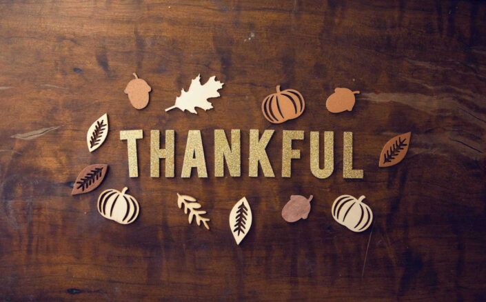 brown wooden board with the word thankful