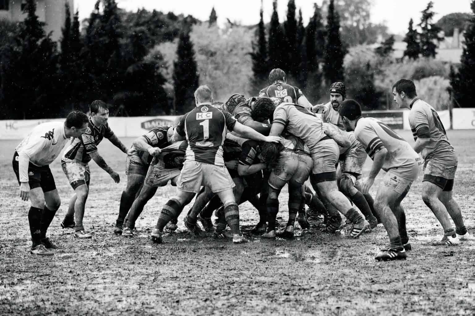 men playing rugby on muddy land