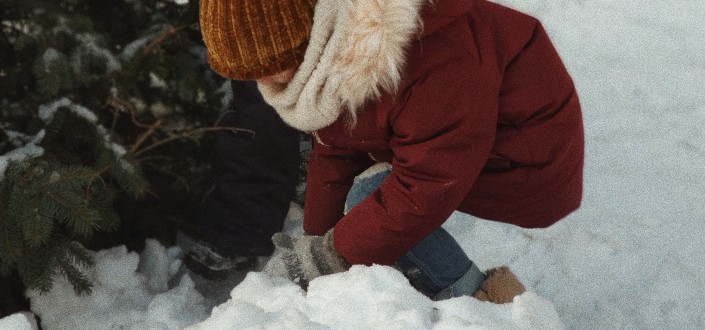 two children playing with snow near tree