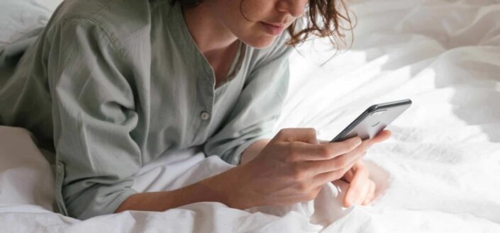 Woman Using Her Phone on the Bed