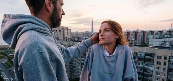 Man fixing his girl's hair at the rooftop
