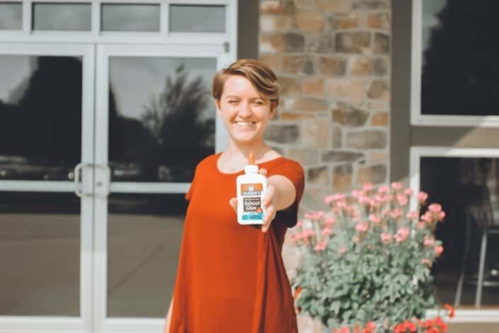 Woman showing glue at camera