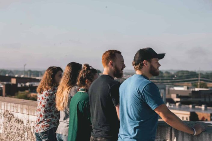 Five friends standing next to each other, looking away.