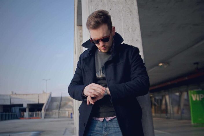 Cool-looking man checking time on his wrist watch.