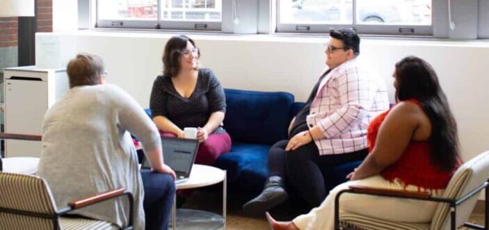 Curvy ladies talking to each other in a spacious living room